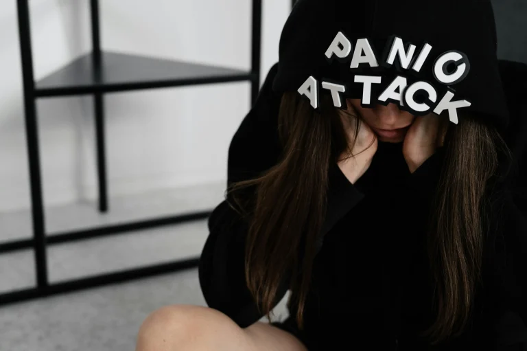a woman wearing a black hoody with words "panic attack"