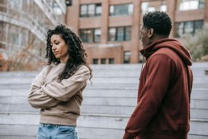 A couple in a heated argument outside, displaying frustration and dissatisfaction.