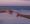 Two hands reaching towards each other on a beach during a serene sunset, evoking connection and tranquility.