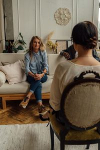 A therapist and client in discussion during a cozy indoor session highlighting mental health. 